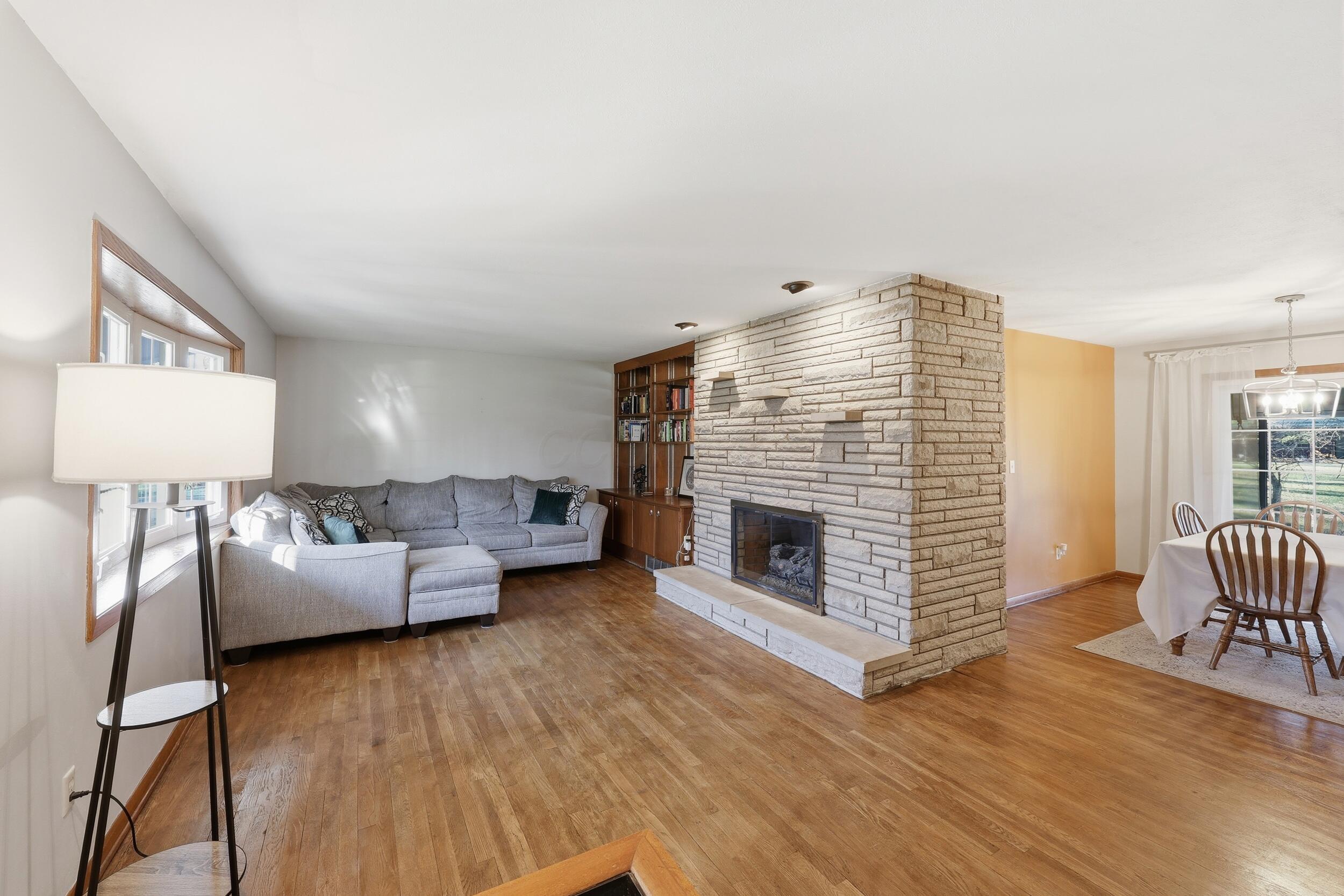7740 Rodebaugh Road Reynoldsburg, OH 43068 - Photo 5 of 45 Refinished floors in living room with gas fireplace leading to dining area...