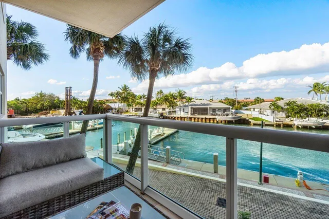 a view of a lake with boats and palm trees