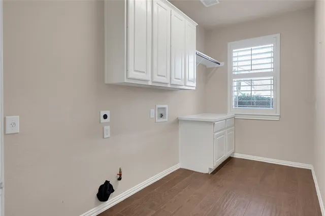 a view of an empty room with wooden floor and a fireplace
