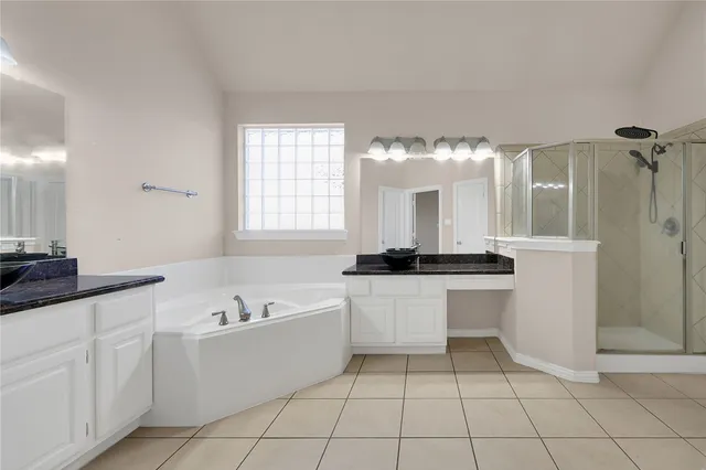 a large white kitchen with a sink a stove and white cabinets