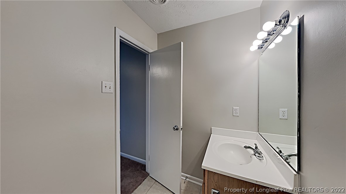 6536 Grist Mill Road Fayetteville, NC 28314 - Photo 4 of 20 a bathroom with a sink a mirror and vanity