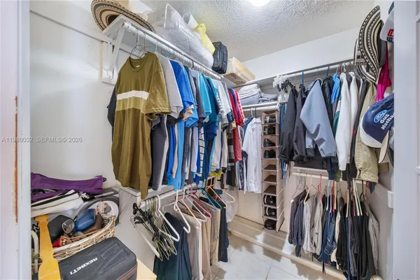 a view of walk in closet with clothes