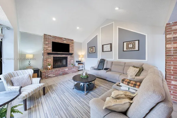 a living room with furniture a flat screen tv and a fireplace