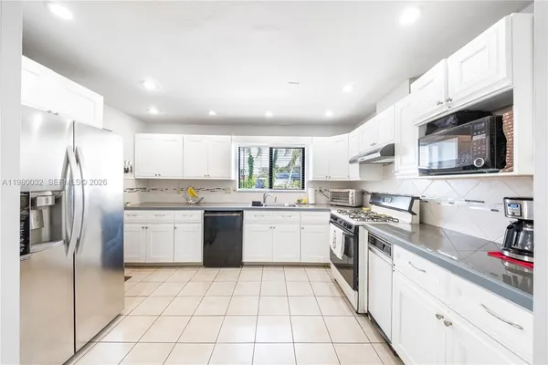 a kitchen with stainless steel appliances granite countertop a refrigerator sink and microwave