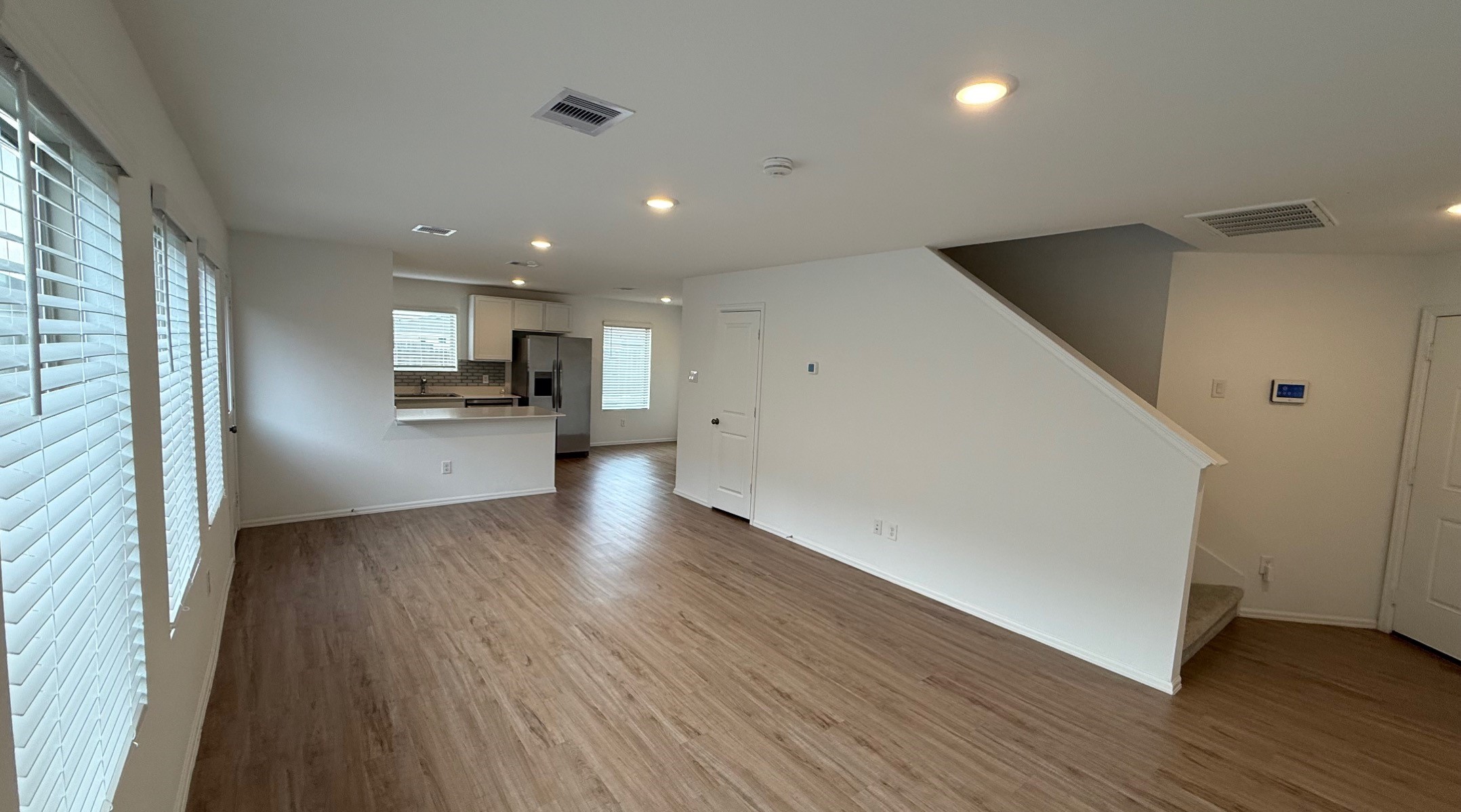 18926 Panzini Drive New Caney, TX 77357 - Photo 3 of 23 an empty room with wooden floor and a kitchen
