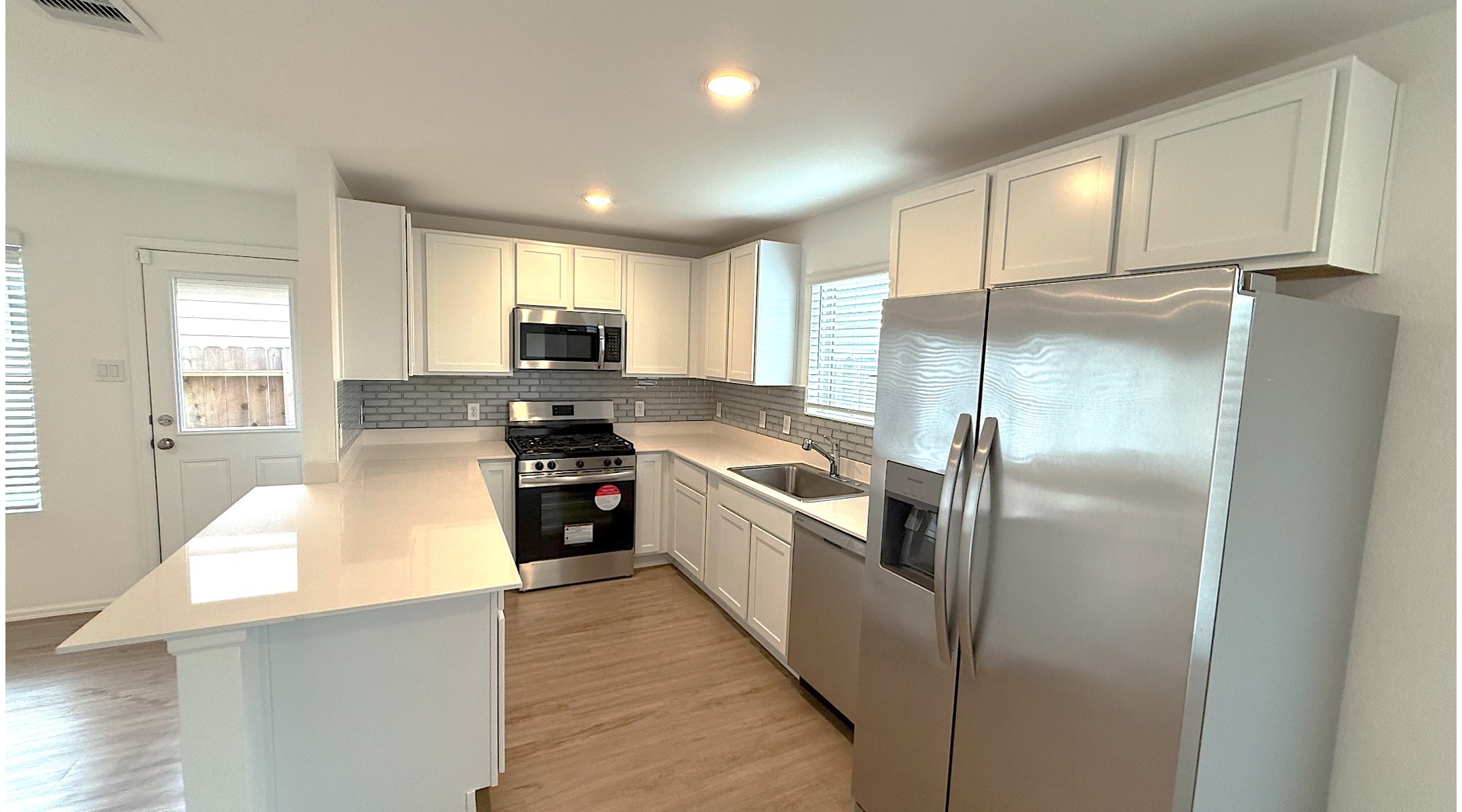 18926 Panzini Drive New Caney, TX 77357 - Photo 6 of 23 a kitchen with granite countertop a refrigerator and a stove top oven