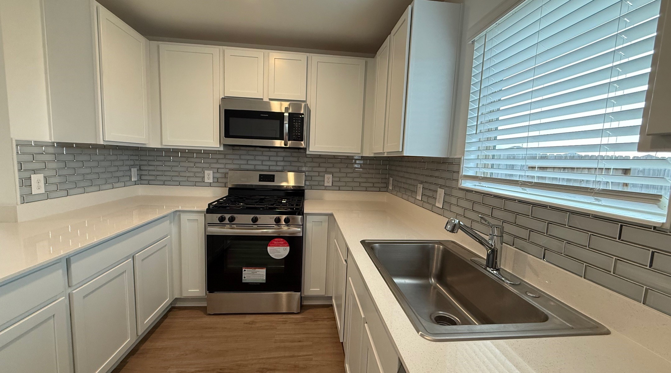 18926 Panzini Drive New Caney, TX 77357 - Photo 7 of 23 a kitchen with granite countertop a sink a stove and cabinets