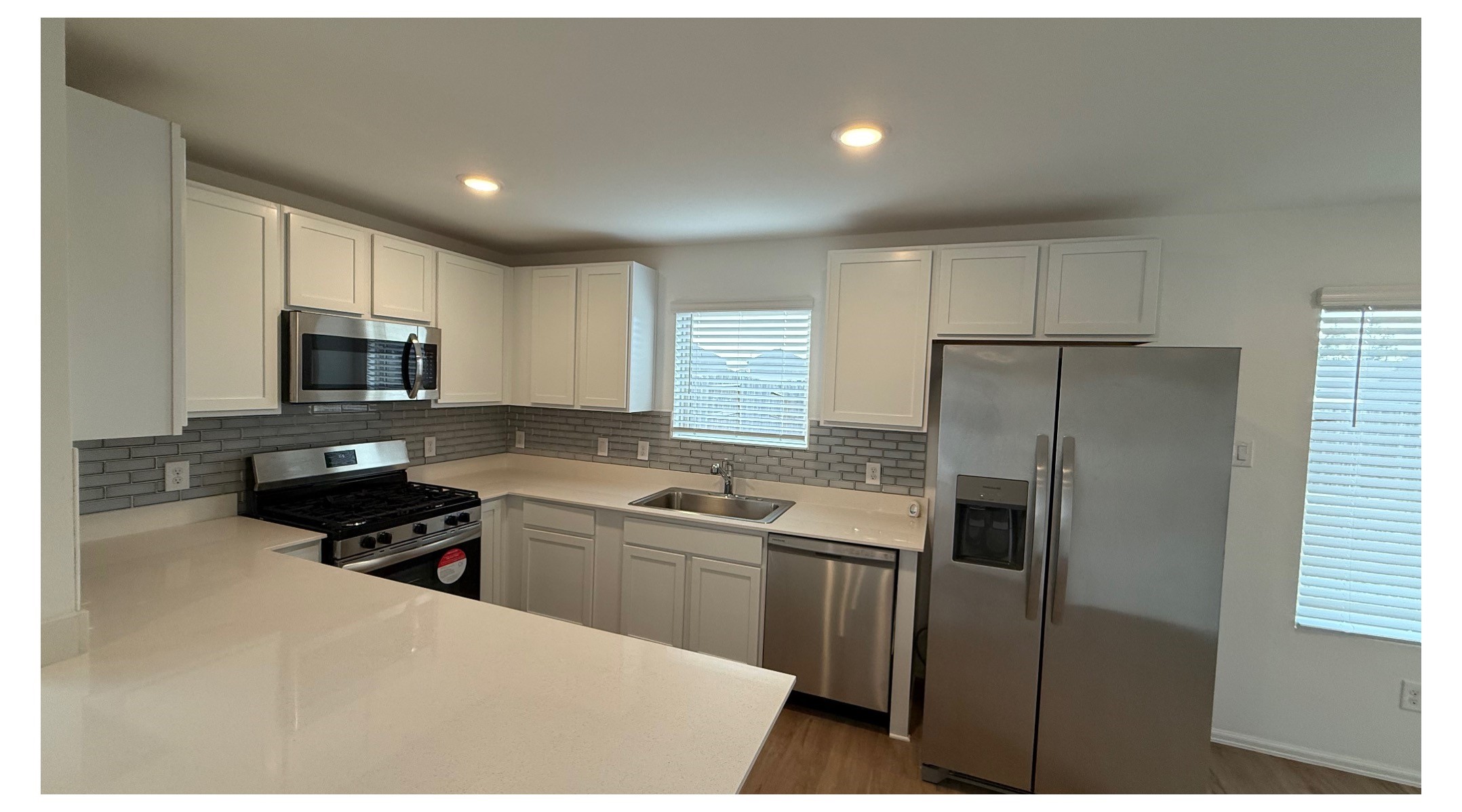 18926 Panzini Drive New Caney, TX 77357 - Photo 10 of 23 a kitchen with a sink a stove a refrigerator cabinets and a window