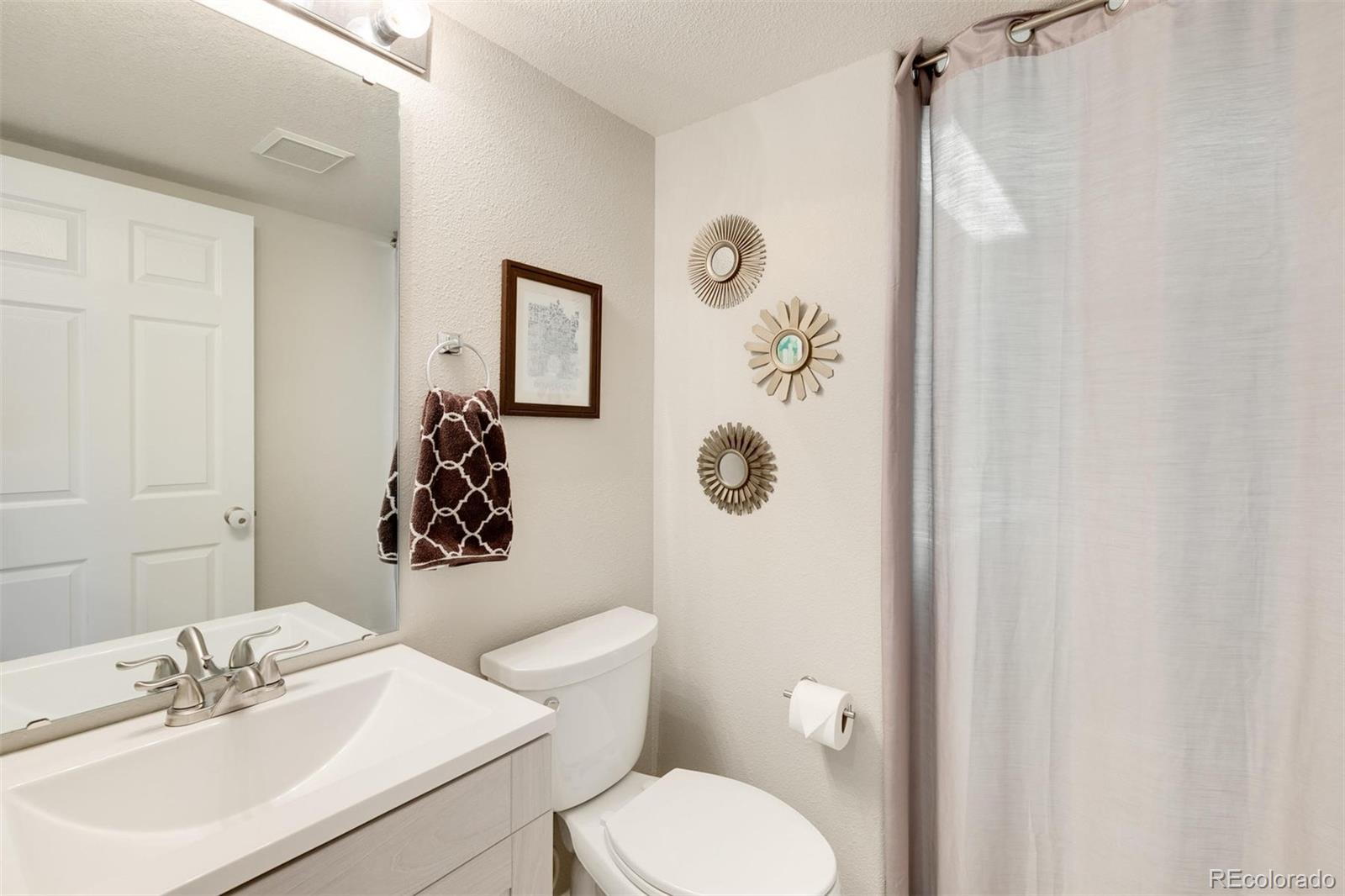 877 Timbervale Trail Highlands Ranch, CO 80129 - Photo 13 of 34 a bathroom with a toilet sink and mirror