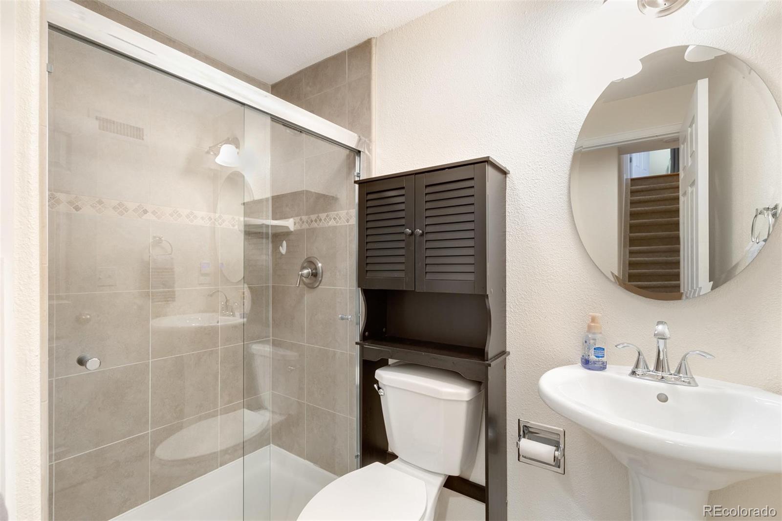 877 Timbervale Trail Highlands Ranch, CO 80129 - Photo 25 of 34 a bathroom with a toilet sink and shower