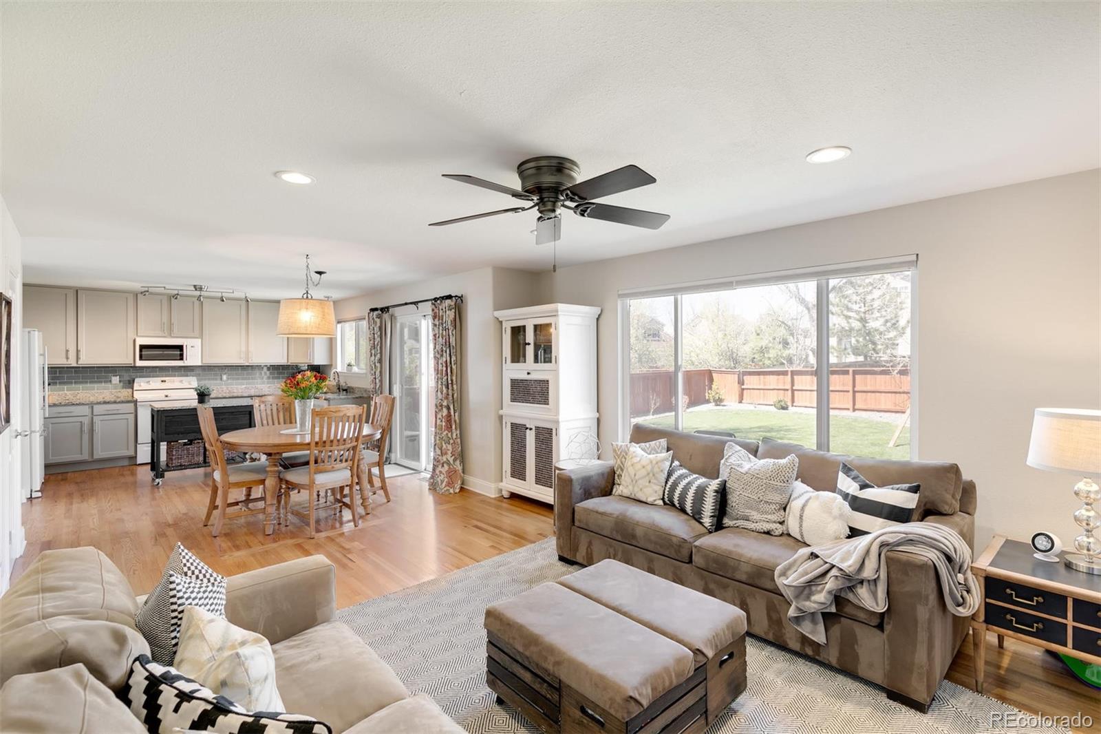 877 Timbervale Trail Highlands Ranch, CO 80129 - Photo 4 of 34 a living room with furniture kitchen area and a large window