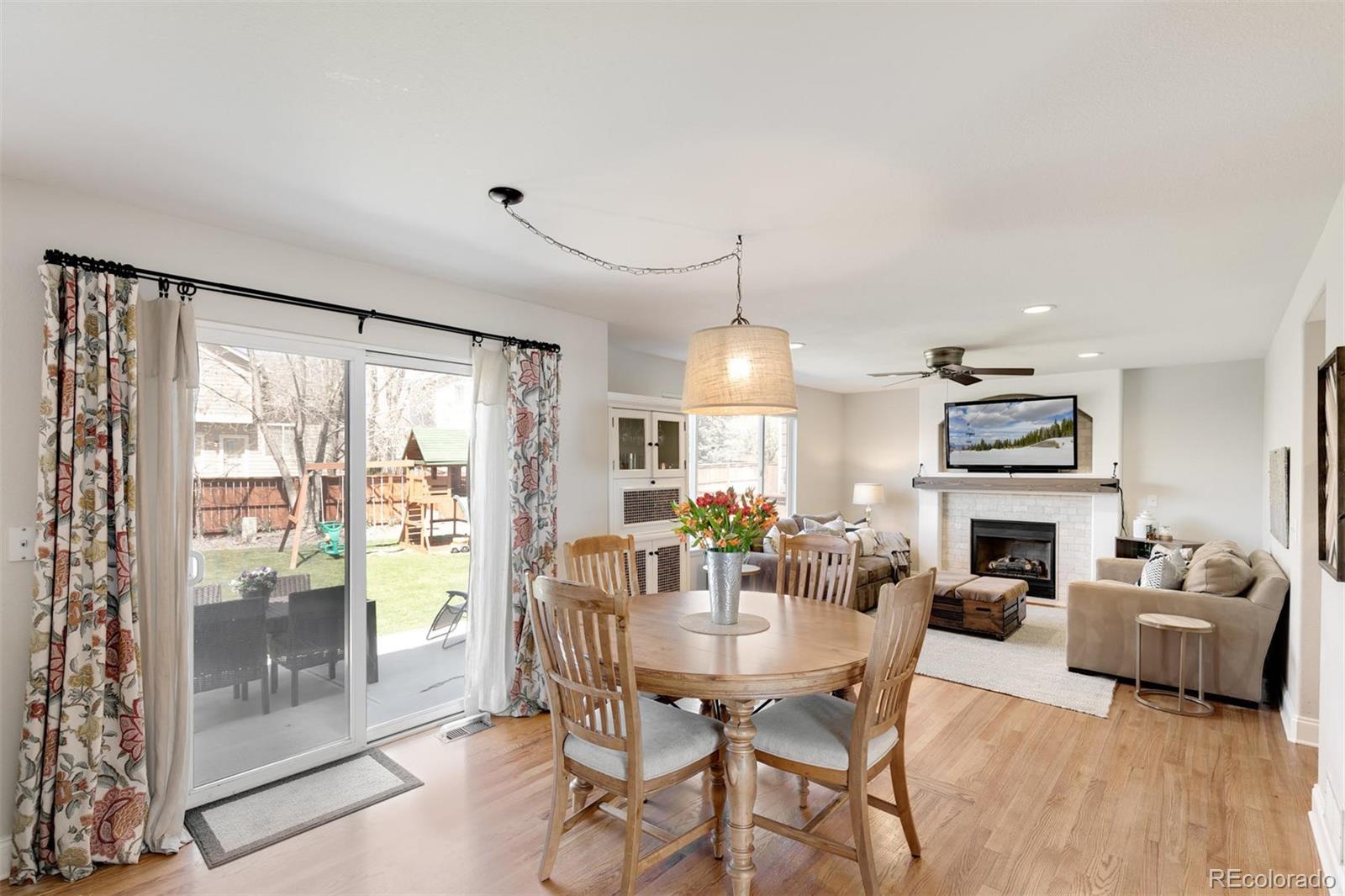 877 Timbervale Trail Highlands Ranch, CO 80129 - Photo 7 of 34 a dining room with furniture a fireplace and wooden floor