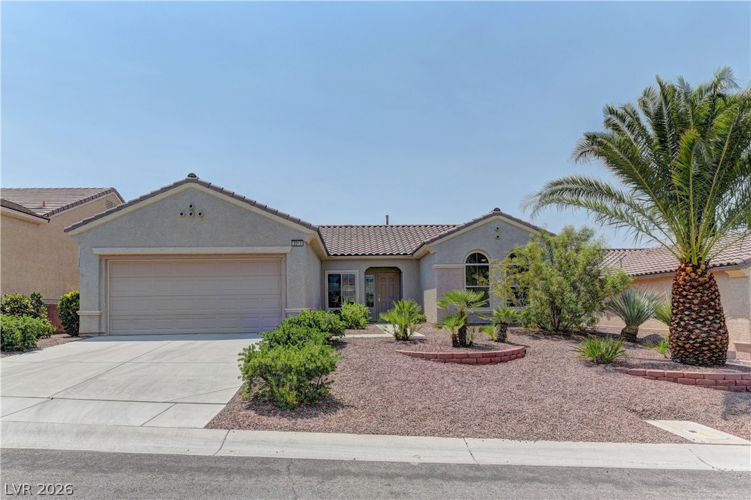 Mediterranean / spanish-style house with stucco siding, a garage, concrete driveway, and a tile roof