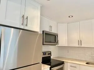 a kitchen with stainless steel appliances white cabinets and a refrigerator