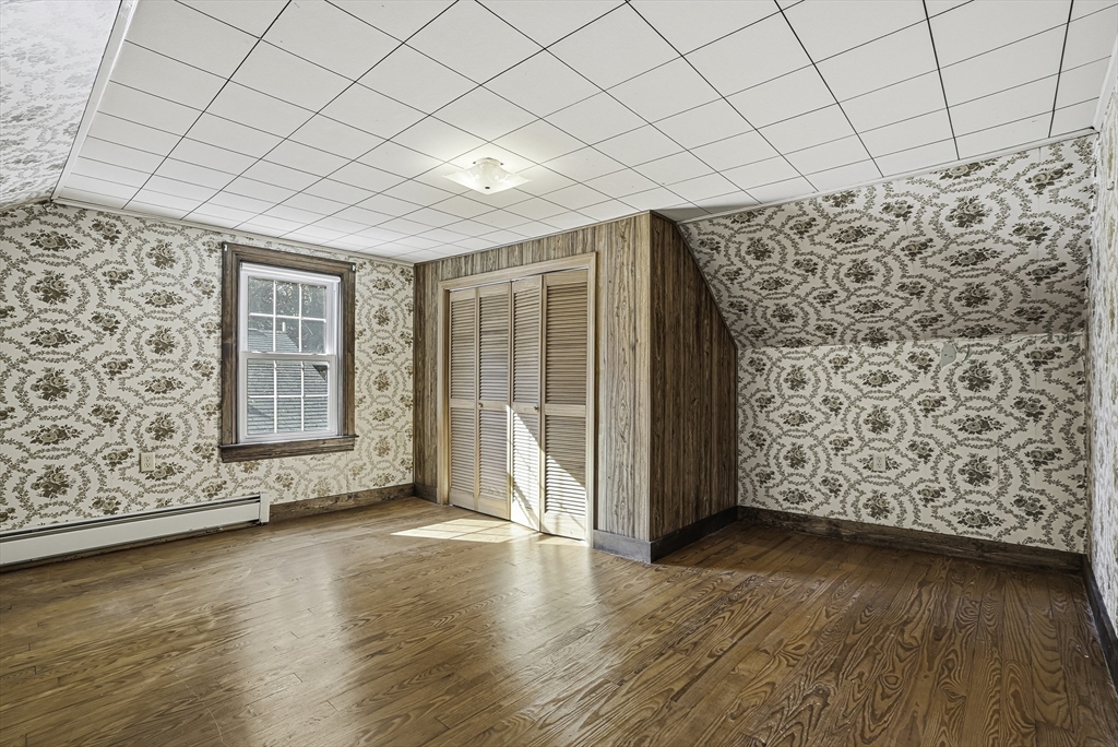 39 Mechanic Street Upton, MA 01568 - Photo 22 of 35 an empty room with wooden floor and windows with curtains