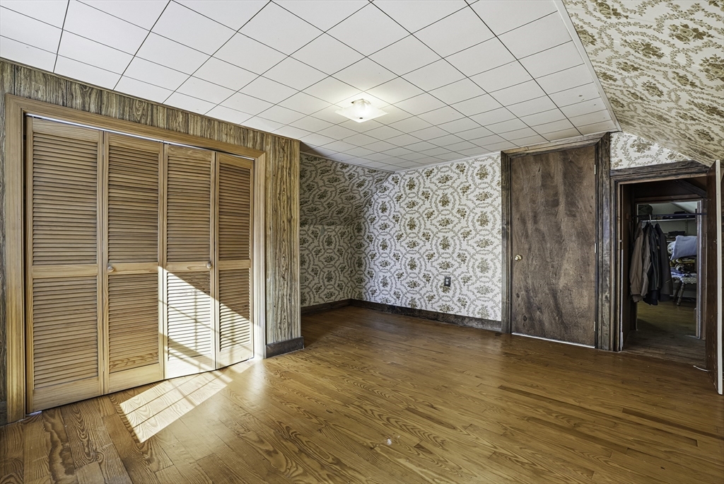 39 Mechanic Street Upton, MA 01568 - Photo 23 of 35 an empty room with wooden floor and cabinet