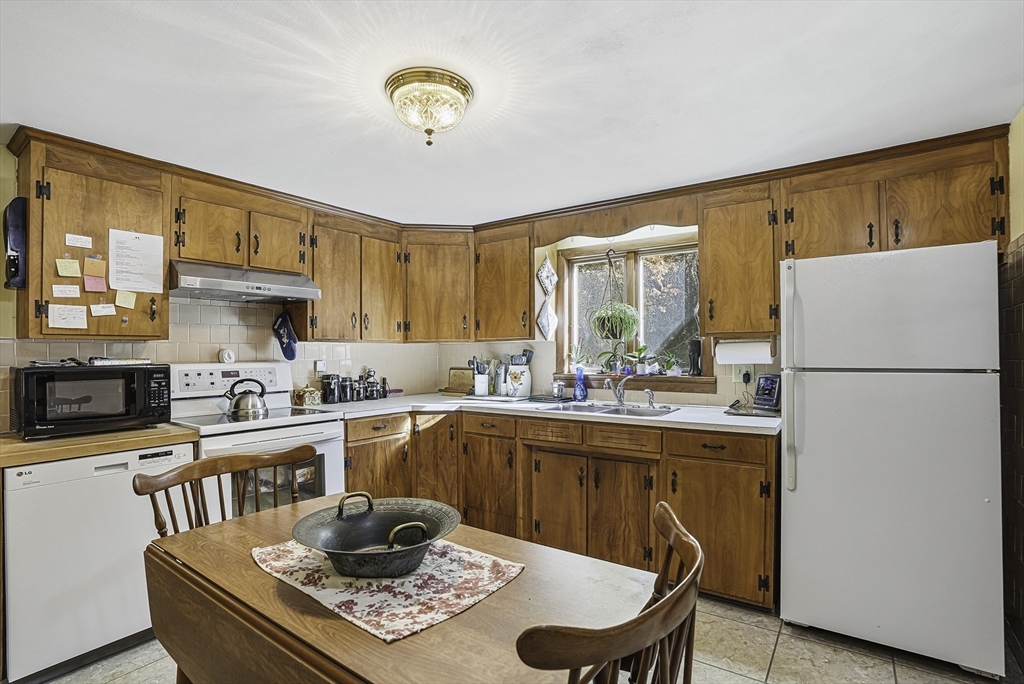 39 Mechanic Street Upton, MA 01568 - Photo 7 of 35 a kitchen with stainless steel appliances granite countertop a refrigerator a stove a sink dishwasher and white cabinets with wooden floor