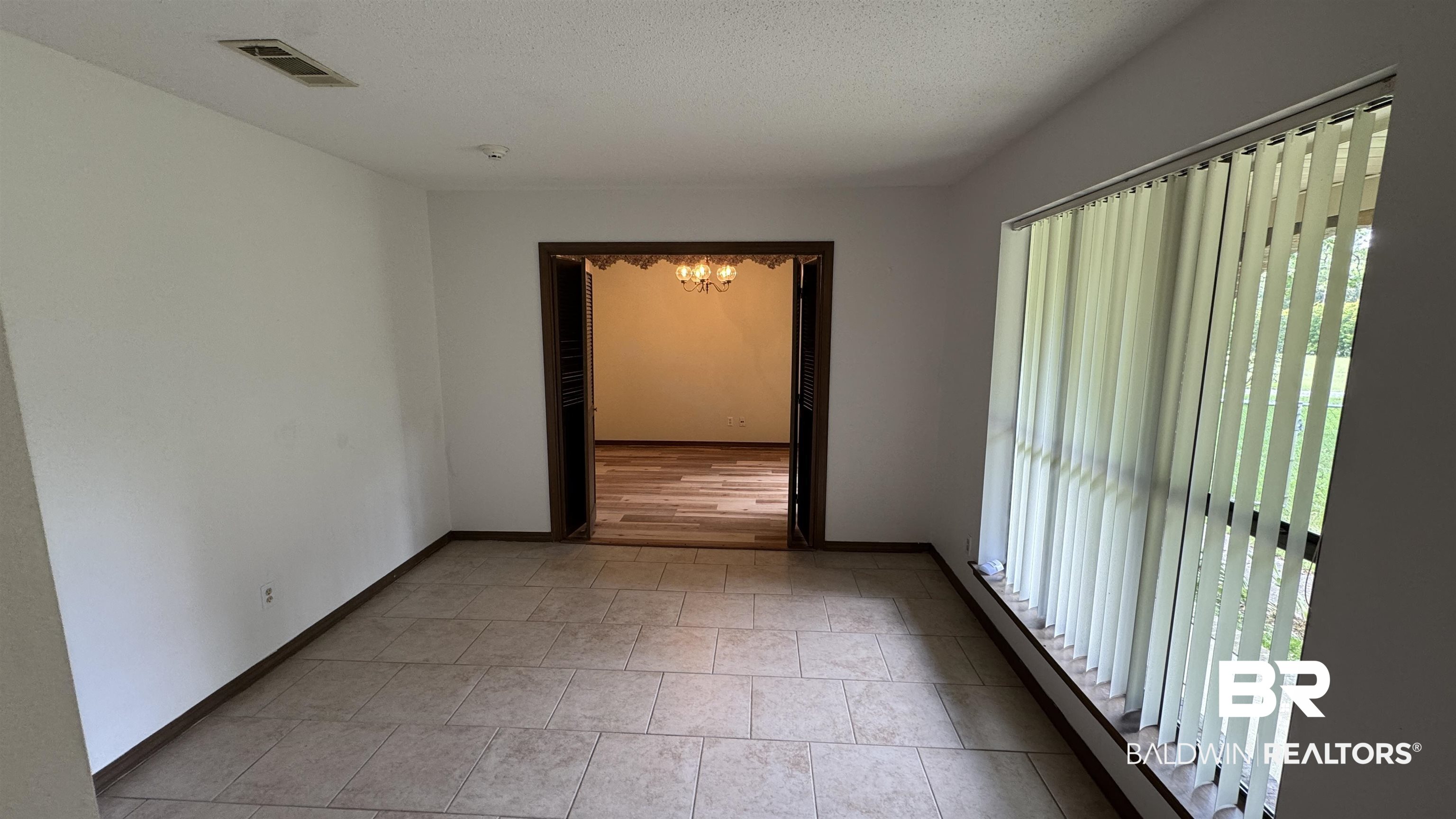 33370 Highway 98 Lillian, AL 36549 - Photo 19 of 58 Spacious room with large format tile flooring and a wide window featuring vertical blinds