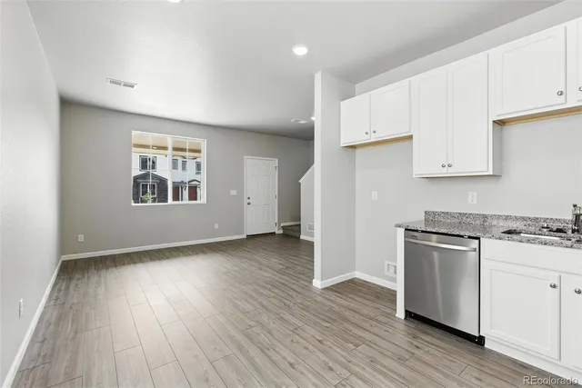 a view of a kitchen with wooden floor and a window