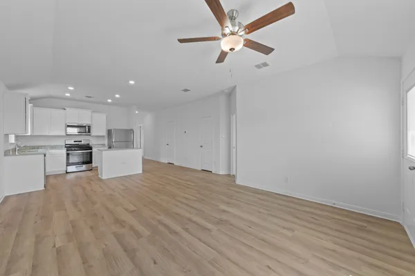 a view of kitchen with microwave and white cabinets