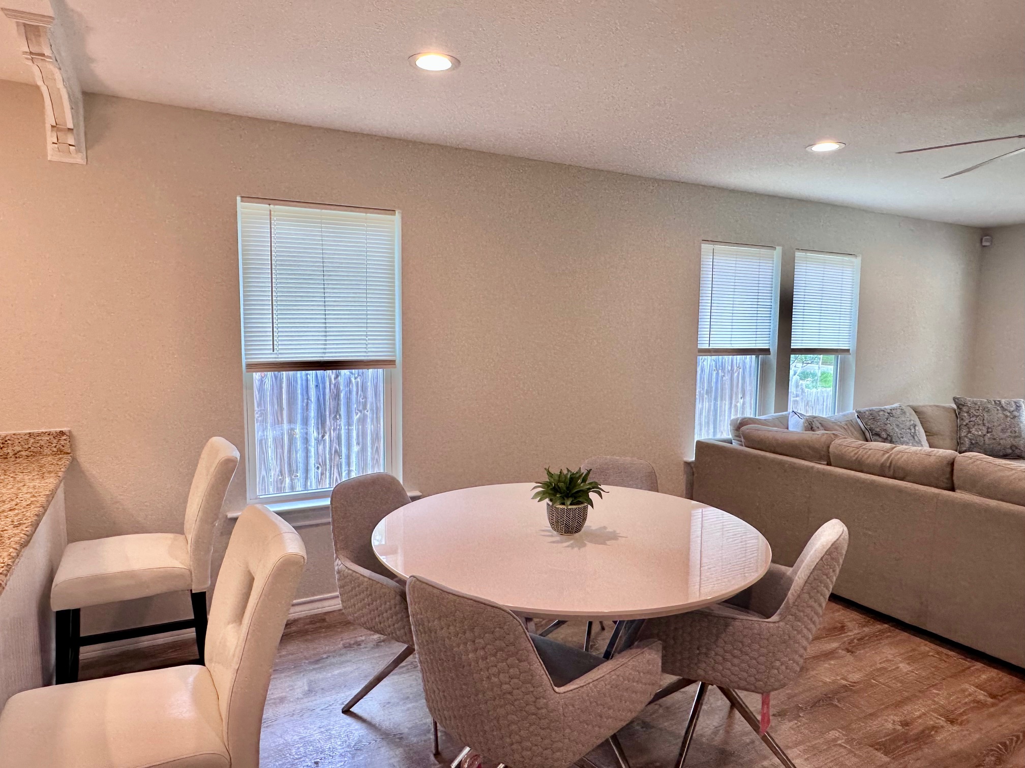 404 Rivers Street Smithville, TX 78957 - Photo 13 of 27 Open-concept dining area featuring wood-finish flooring, recessed lighting, and multiple windows with blinds