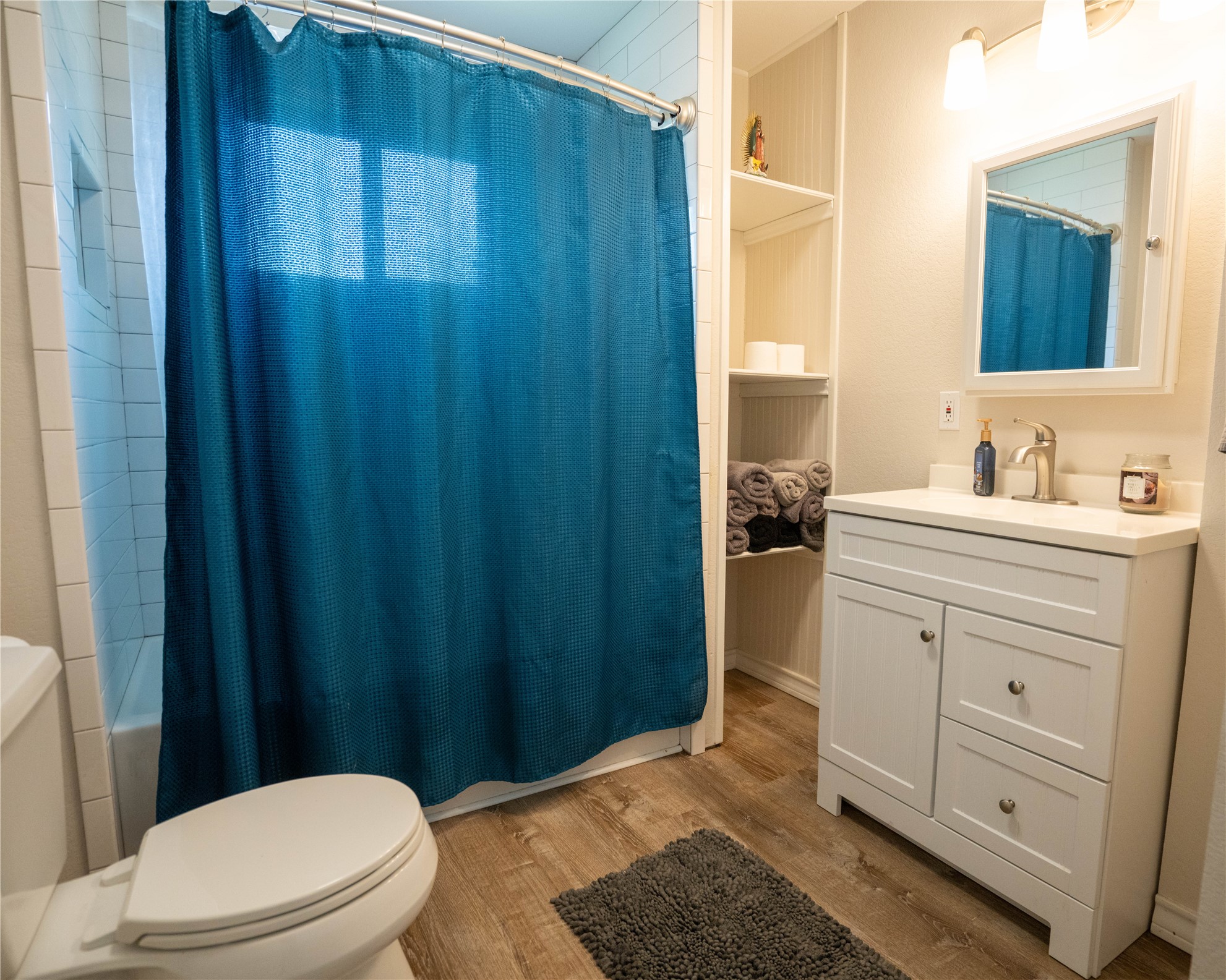 404 Rivers Street Smithville, TX 78957 - Photo 16 of 27 Bathroom featuring a white vanity with integrated sink, brushed nickel faucet, and wood-finish flooring