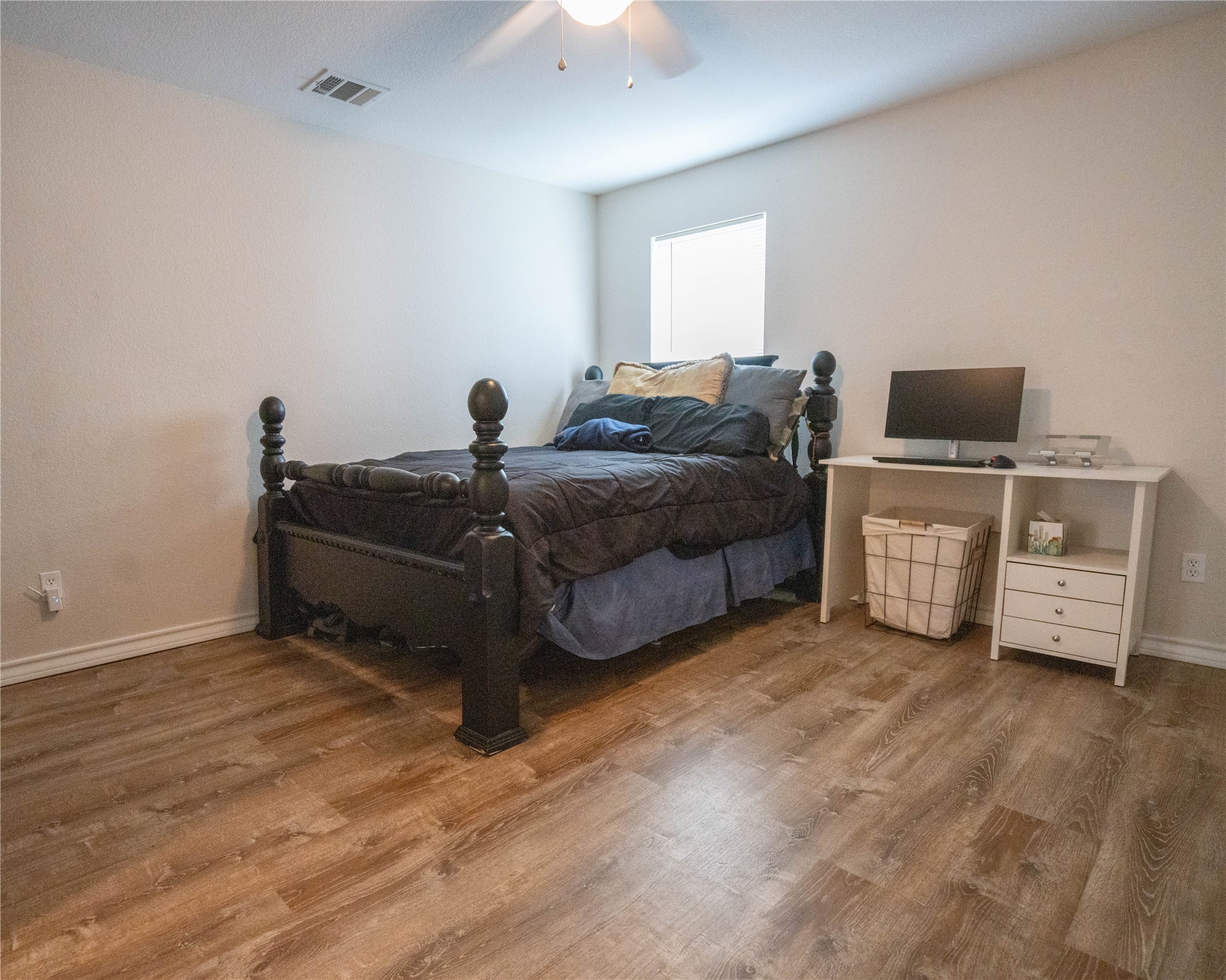 404 Rivers Street Smithville, TX 78957 - Photo 17 of 27 Room featuring wood-finish flooring, a ceiling fan, baseboard molding, and a window providing natural light
