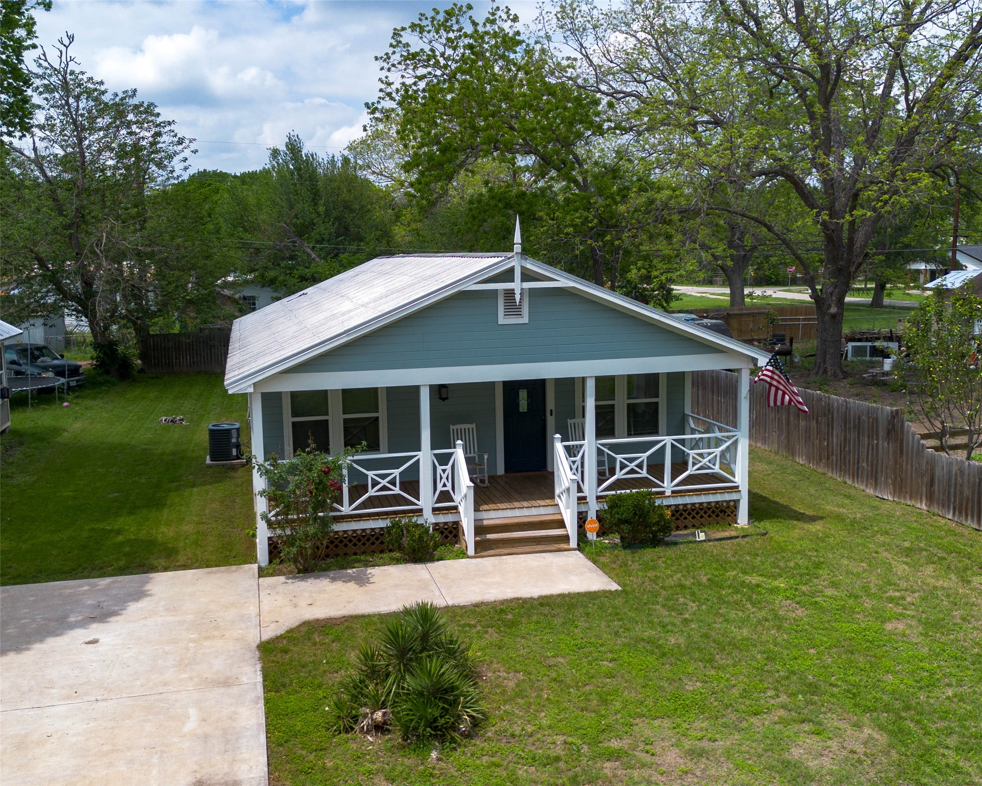 404 Rivers Street Smithville, TX 78957 - Photo 22 of 27 Front elevation featuring a covered porch with white railing, blue siding, and a light-colored roof