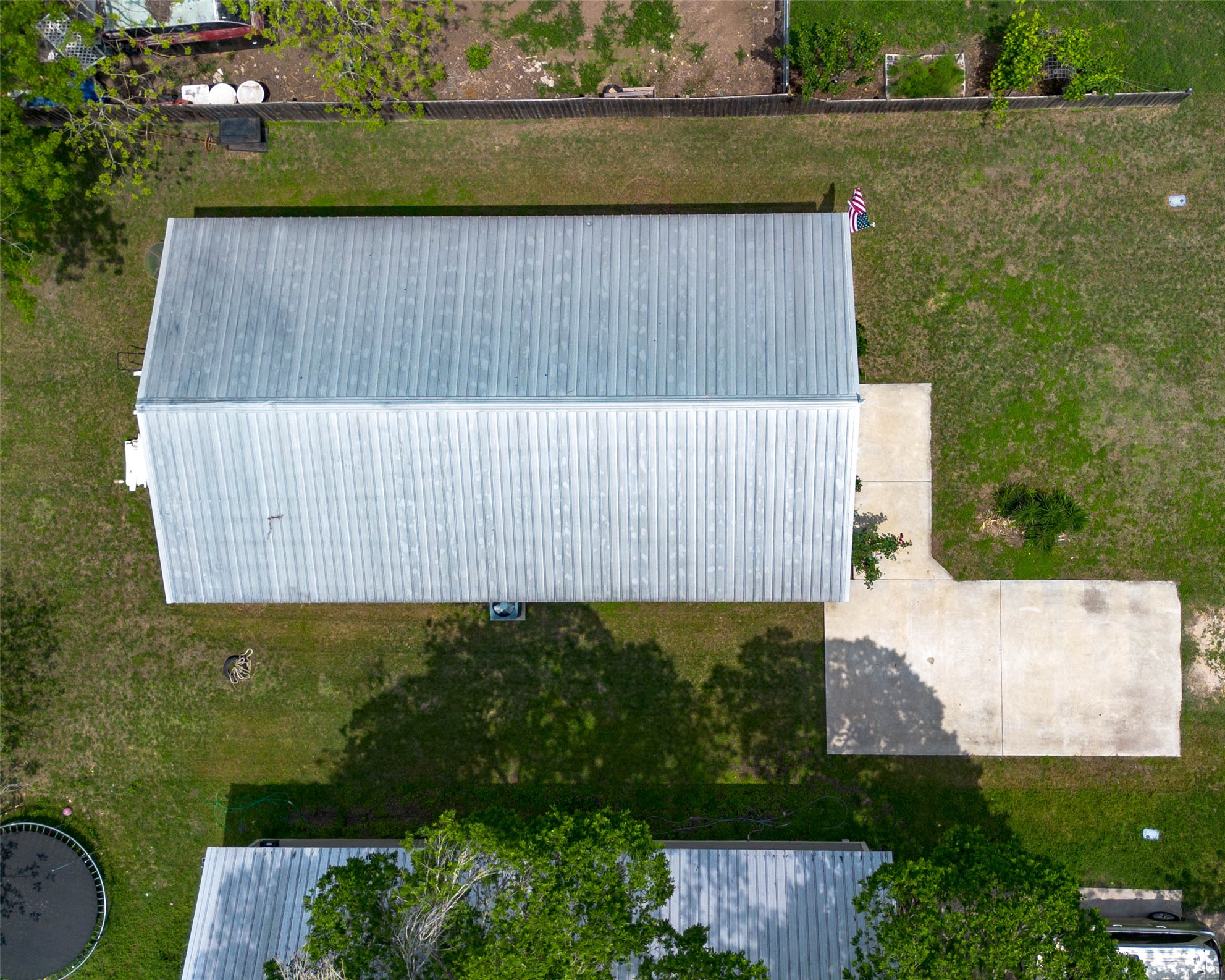 404 Rivers Street Smithville, TX 78957 - Photo 24 of 27 Aerial perspective highlighting the property's metal roof and concrete patio