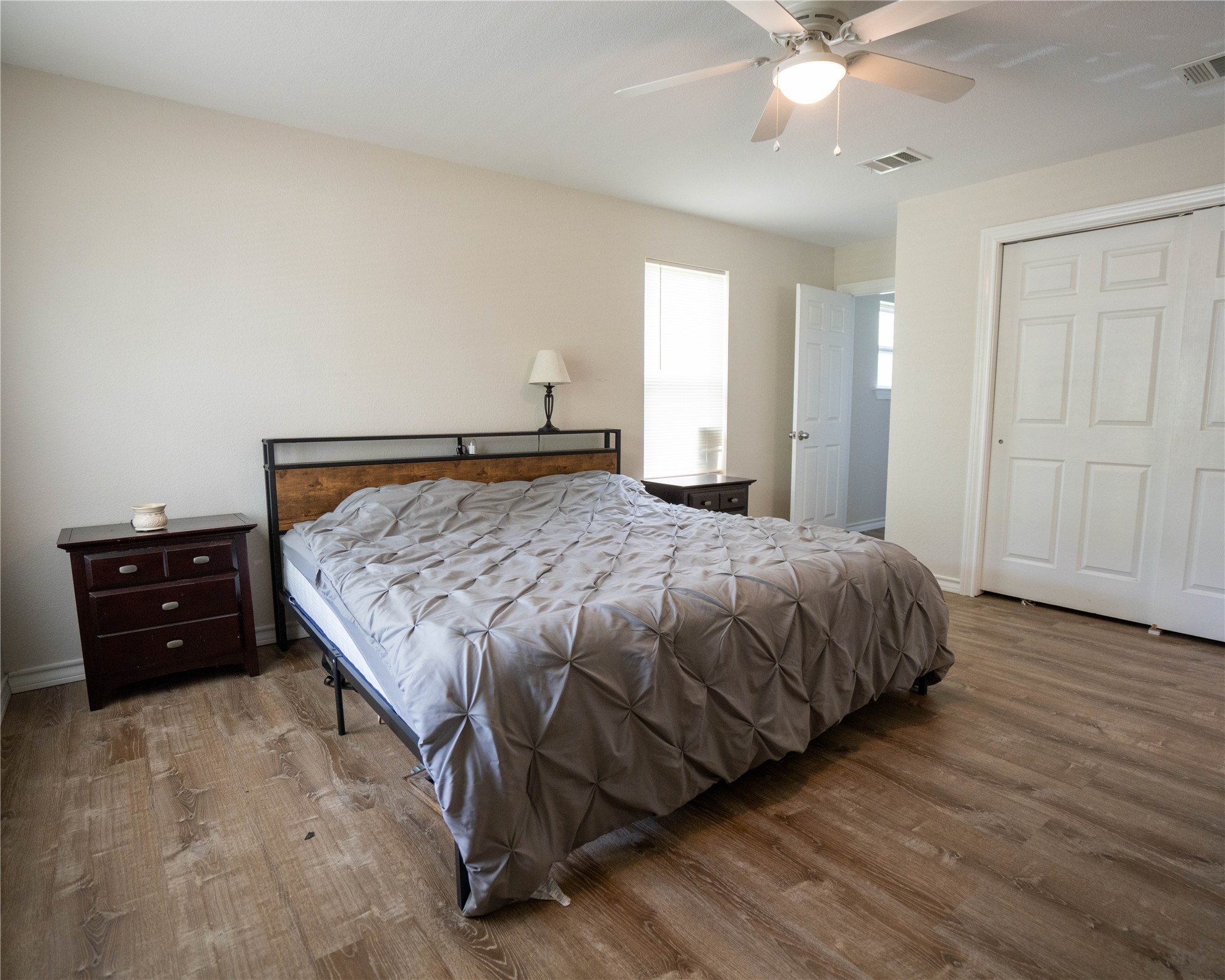 404 Rivers Street Smithville, TX 78957 - Photo 4 of 27 Spacious room featuring wood-finish flooring, a vaulted ceiling, and a ceiling fan with integrated lighting
