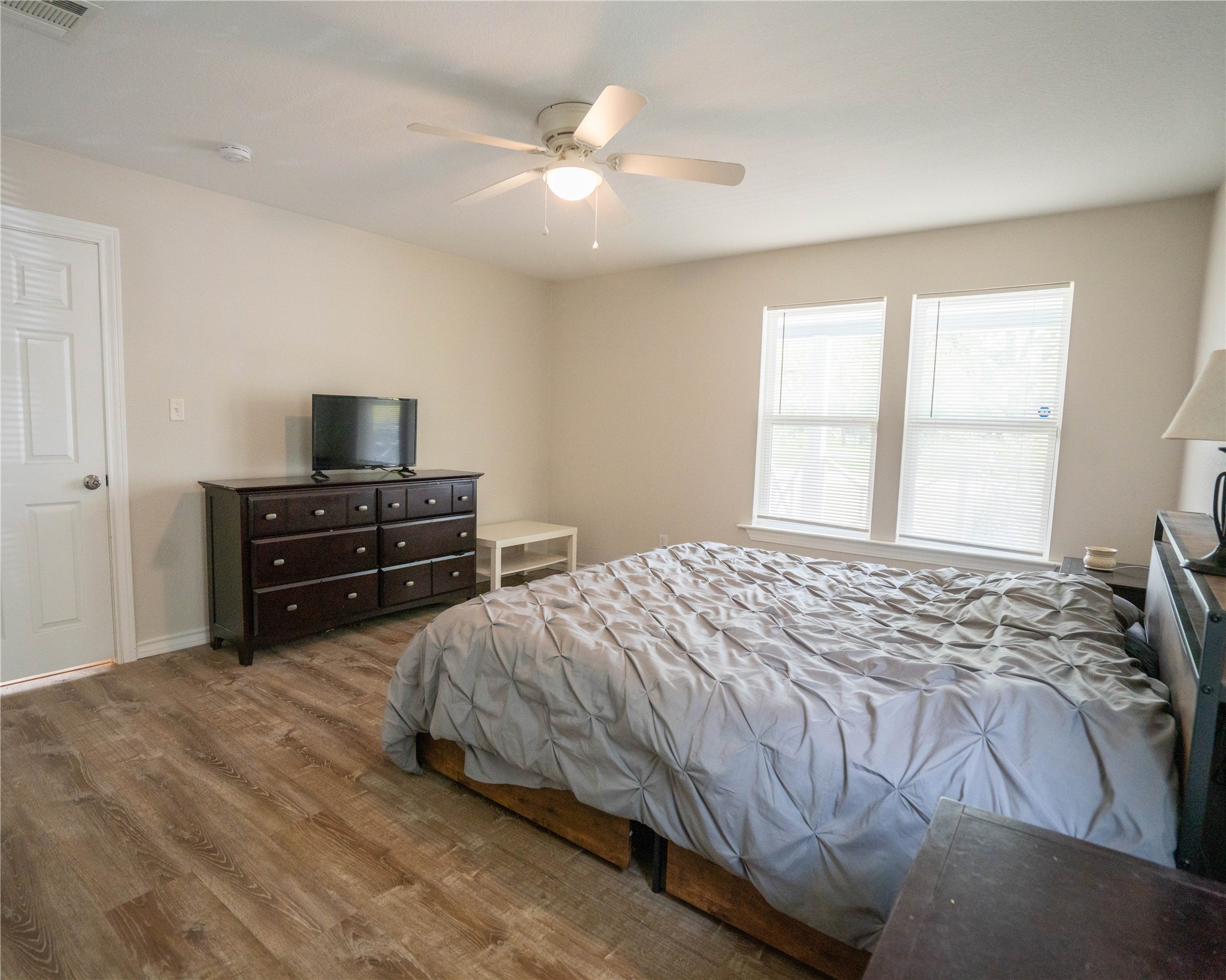 404 Rivers Street Smithville, TX 78957 - Photo 6 of 27 Spacious room featuring wood-finish flooring, light-toned walls, and a ceiling fan with integrated lighting
