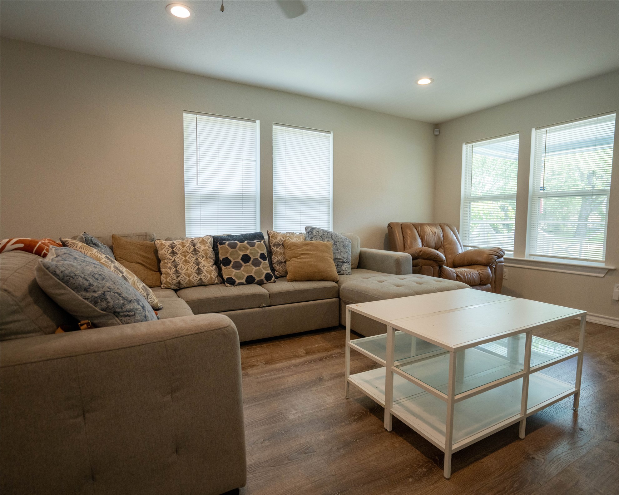 404 Rivers Street Smithville, TX 78957 - Photo 10 of 27 Spacious room featuring wood-finish flooring, recessed lighting, and multiple windows with blinds
