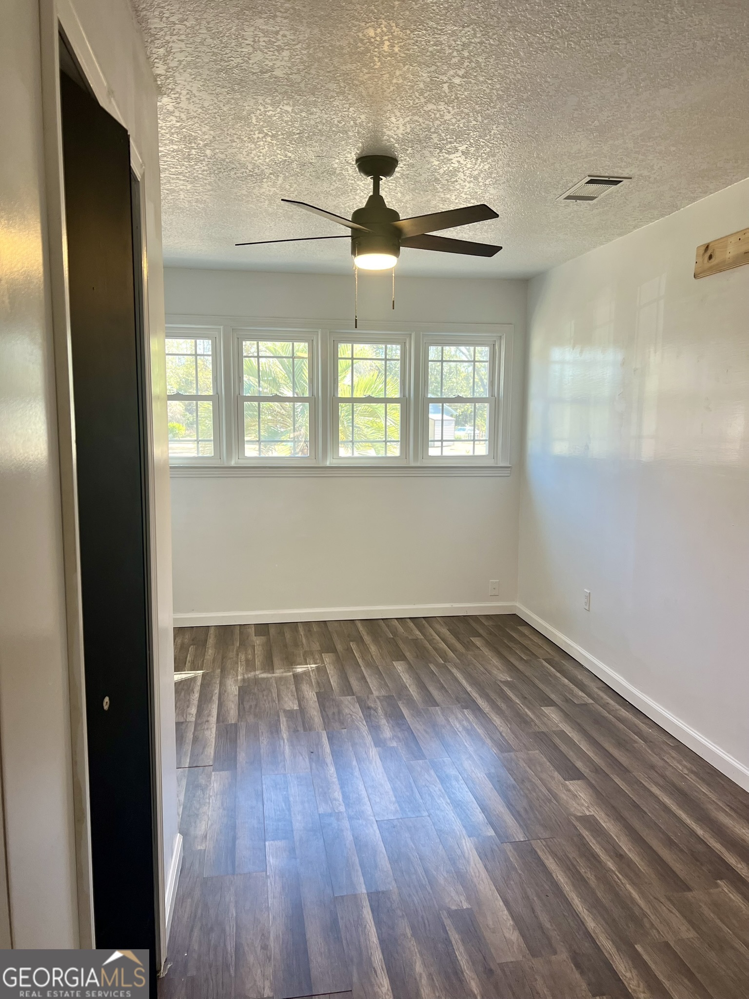 594 South 3rd Street Jesup, GA 31545 - Photo 12 of 32 a view of an empty room with wooden floor and a window