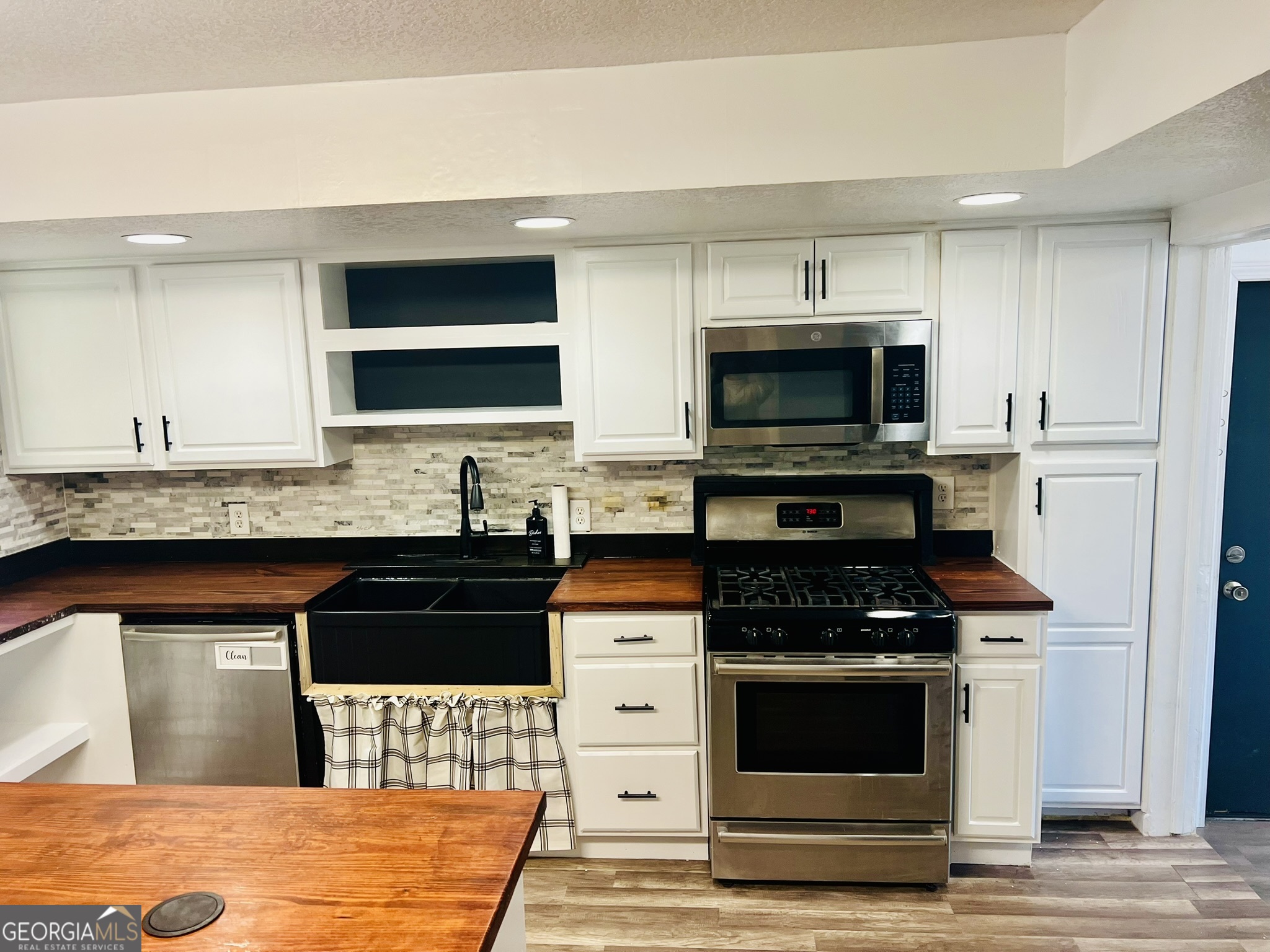 594 South 3rd Street Jesup, GA 31545 - Photo 16 of 32 a kitchen with stainless steel appliances kitchen island granite countertop a stove and a sink
