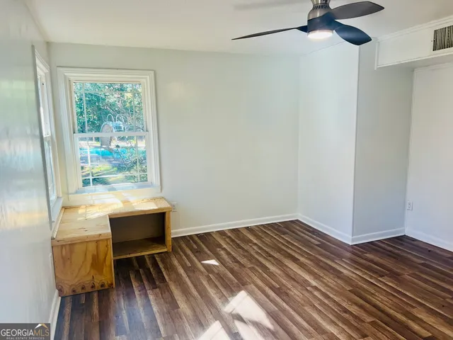 a room with wooden floor table and chairs