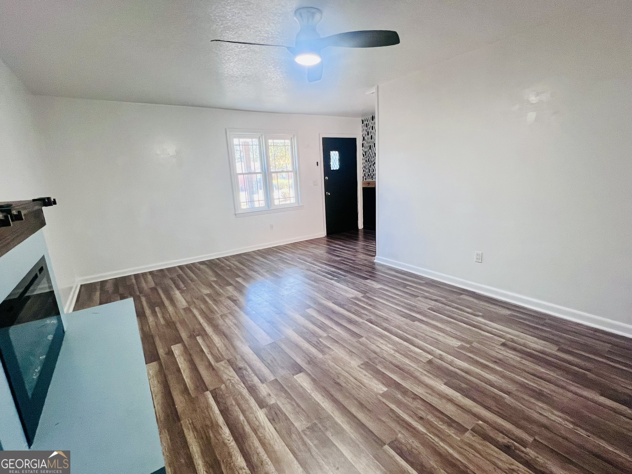 594 South 3rd Street Jesup, GA 31545 - Photo 9 of 32 an empty room with wooden floor and windows