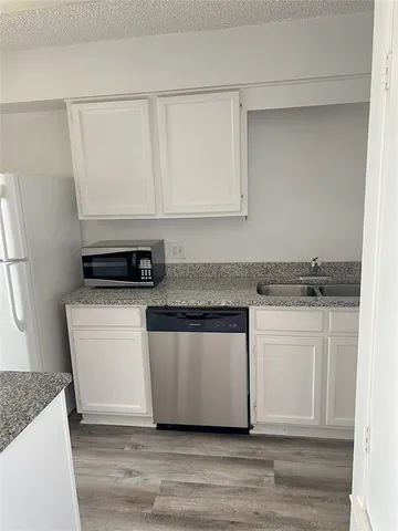 a kitchen with stainless steel appliances white cabinets and a granite counter tops