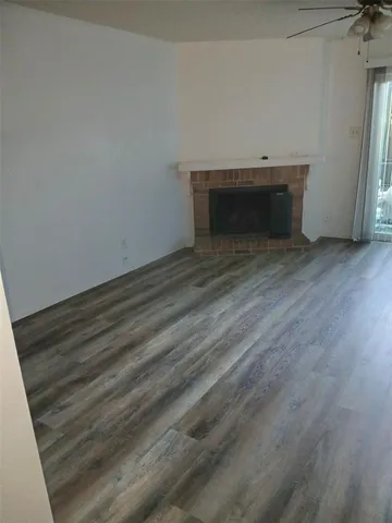 a view of an empty room with wooden floor and closet
