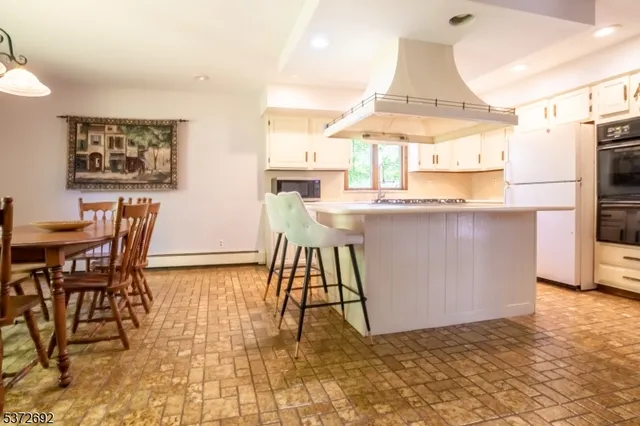 a living room with a table chairs and a dining table with kitchen view