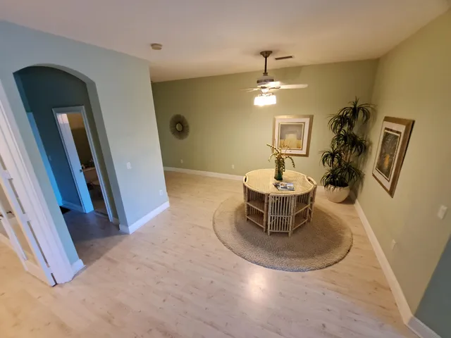 a view of a hallway with dining room and chandelier