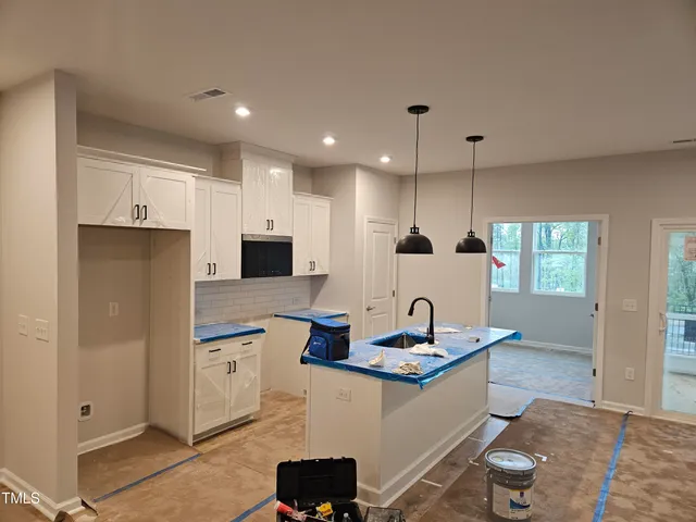 a large kitchen with kitchen island a counter top space appliances and a window