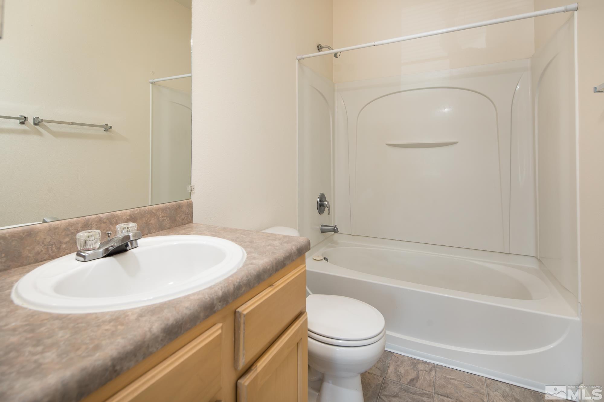 200 Talus Way, Unit 414 Reno, NV 89503 - Photo 14 of 22 a bathroom with a granite countertop sink toilet and shower