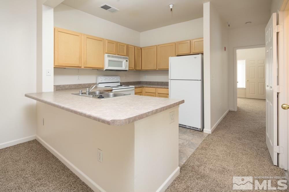 200 Talus Way, Unit 414 Reno, NV 89503 - Photo 8 of 22 a kitchen with a sink a stove a refrigerator and cabinets