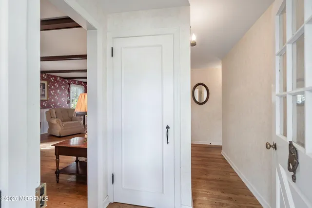 a view of a hallway with wooden floor and closet area