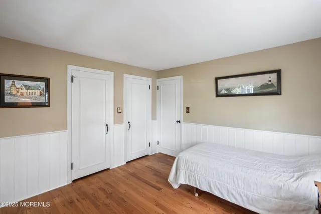 a bedroom with a bed and painting on the wall