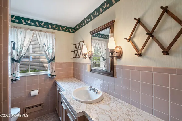 a bathroom with a granite countertop sink a toilet and a mirror