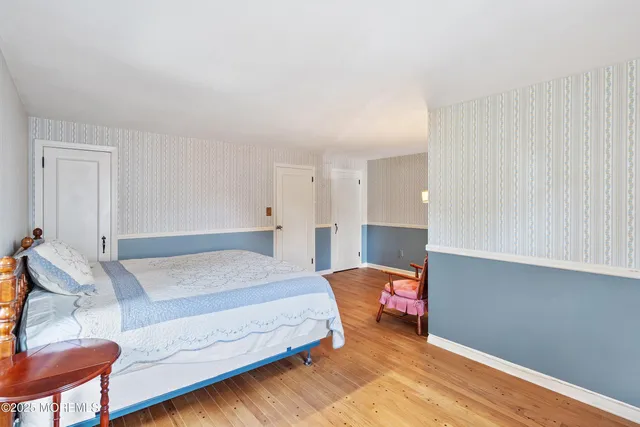 a bedroom with a bed and a lamp on dresser