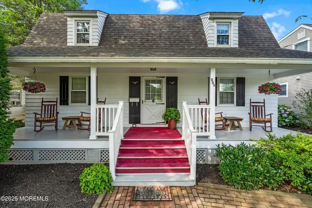 a front view of a house with garden and seating area