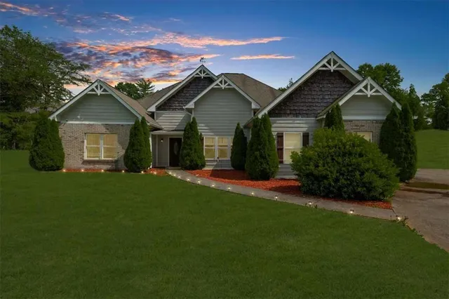 a front view of a house with a garden and yard