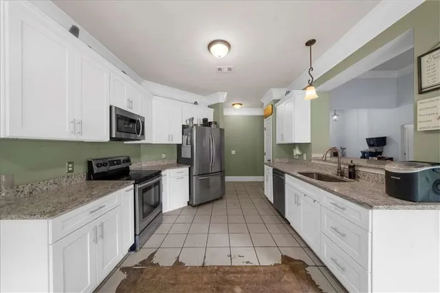 a large white kitchen with stainless steel appliances granite countertop a stove a sink dishwasher and a refrigerator
